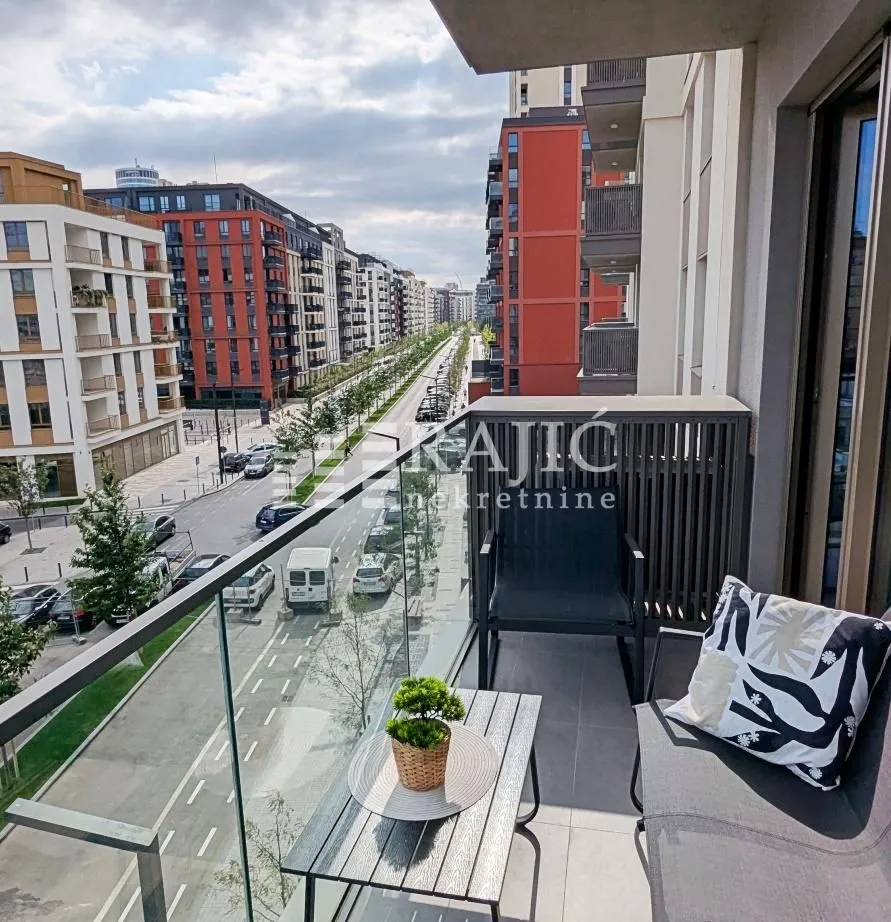 Furnished balcony with seating set and street view.
