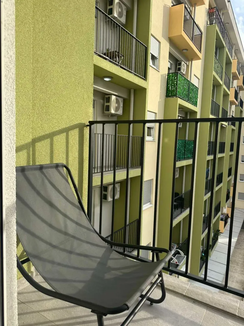 Pogled sa balkona na fasadu zgrade i susjedne terase.