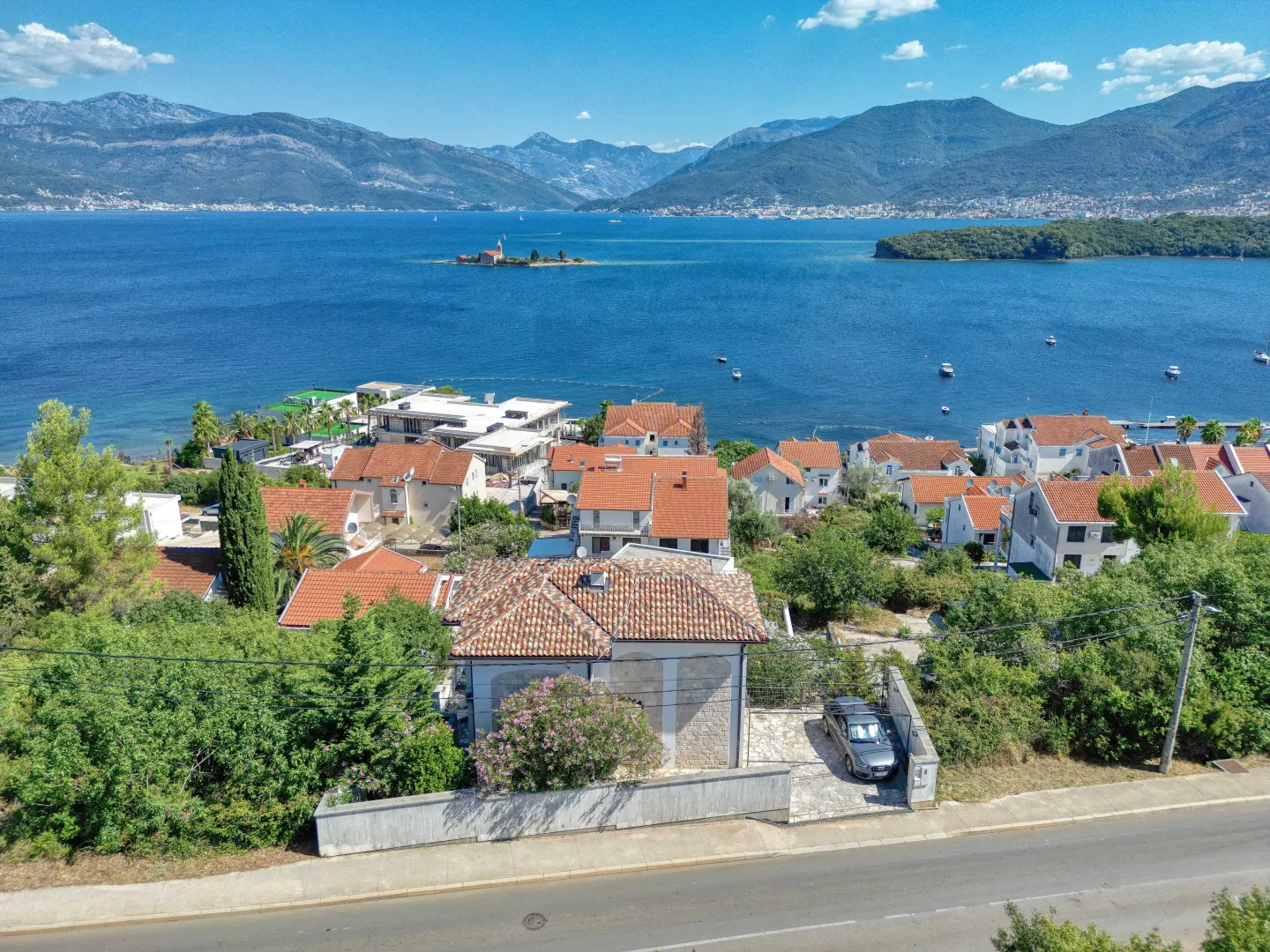 Pogled iz vazduha na kuću sa dvorištem i pogledom na more.