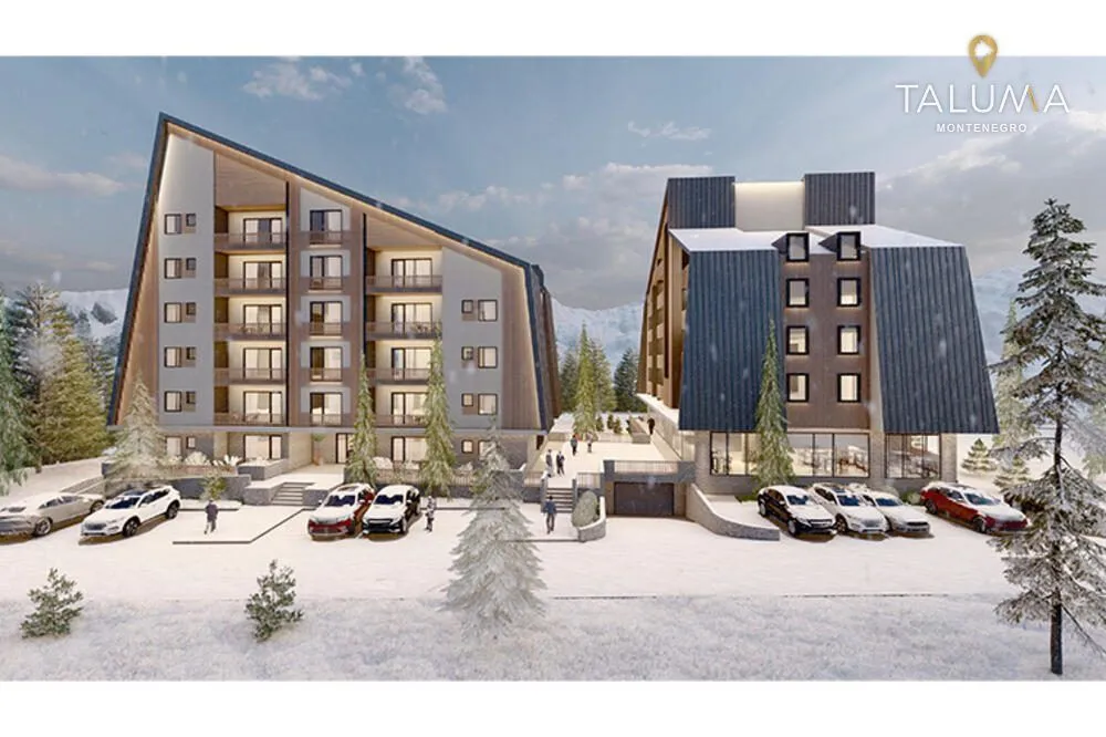 Spoljašnji izgled moderne planinske zgrade sa snijegom prekrivenim okruženjem i parkingom.