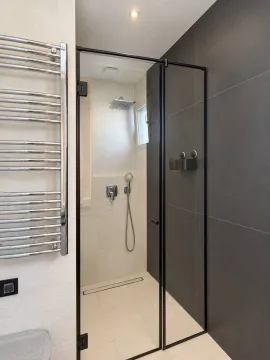 Moderno opremljeno kupatilo sa tuš kabinom i crnim okvirom. - image 7