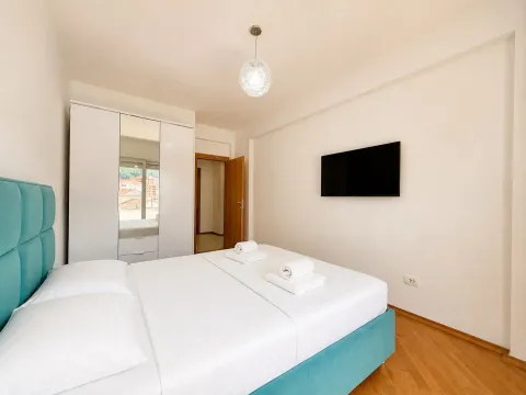 Modern bedroom with a double bed, wardrobe, and television. - image 3