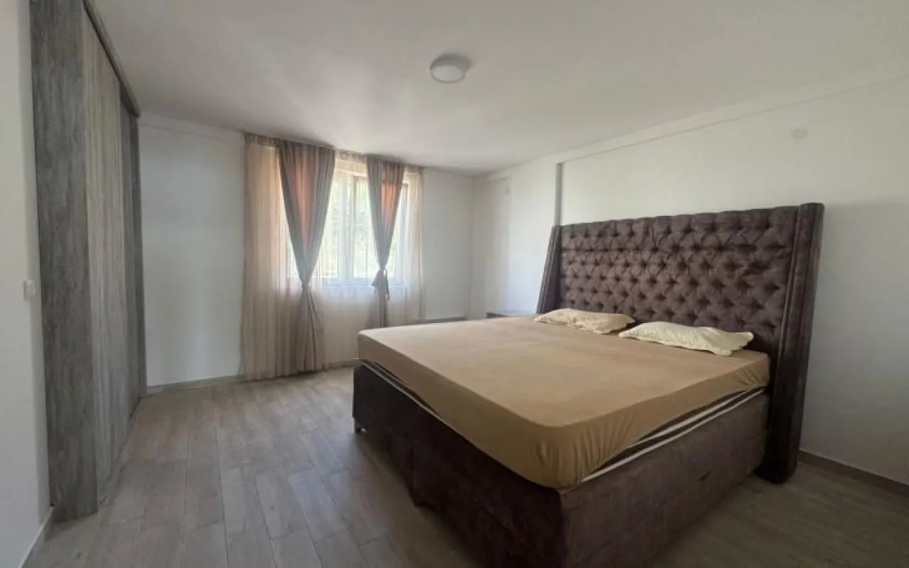 Prostrana spavaća soba sa velikim bračnim krevetom i ugradnim ormarom.