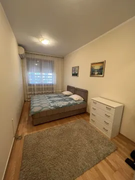 A simply furnished bedroom with a double bed and a chest of drawers. - image 7