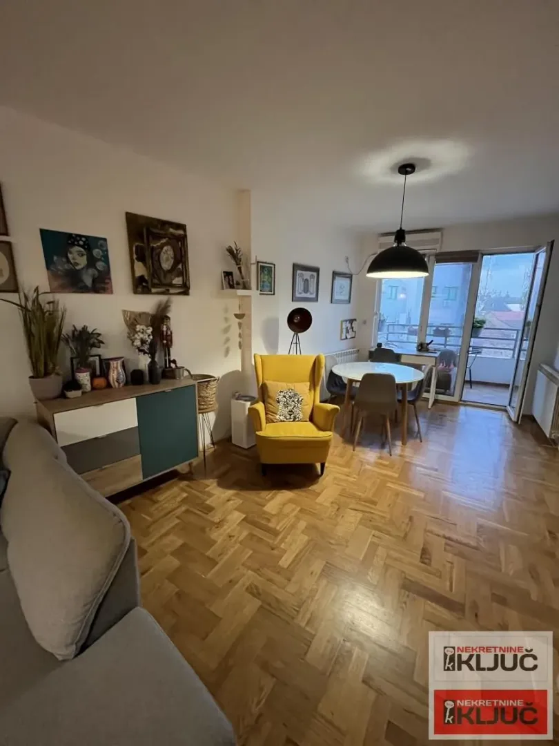 Dnevna soba sa garniturom, trpezarijom i izlazom na terasu.