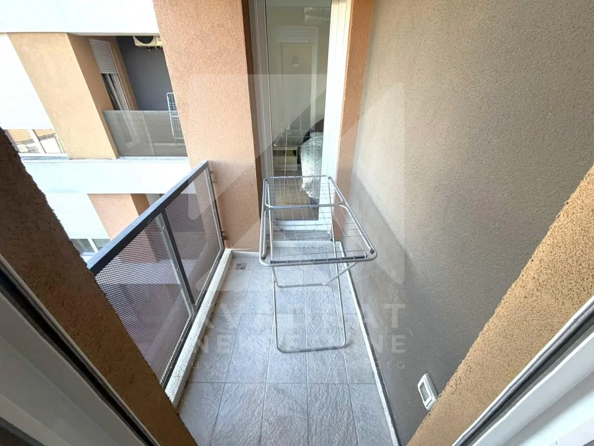Small tiled balcony with a clothes drying rack.