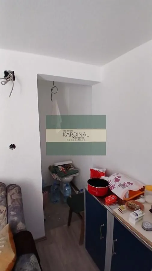 Pogled na deo unutrašnjosti stana sa kuhinjskim elementima i prolazom.