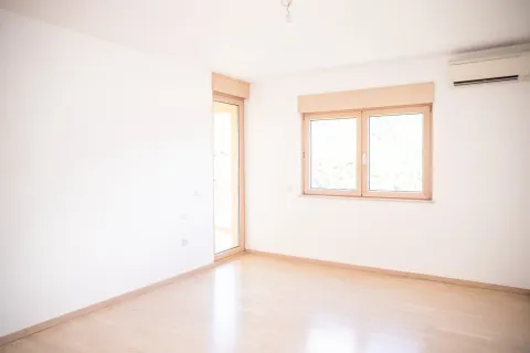 Prazna svijetla soba sa prozorom, drvenim podom i klima uređajem. - image 2