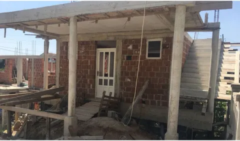 A house under construction with concrete pillars and outdoor stairs. - image 6