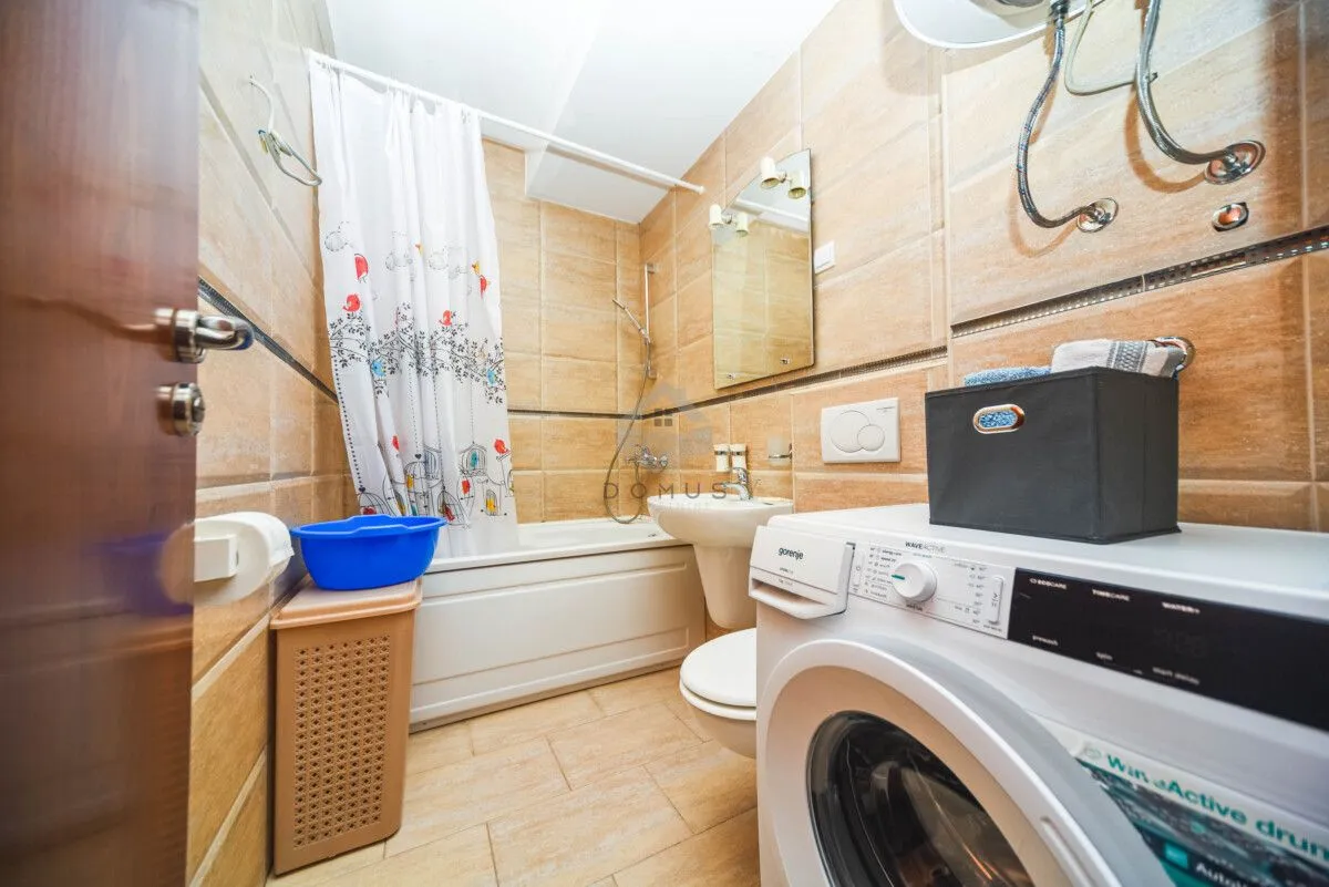 Bathroom equipped with a bathtub, washbasin, toilet, and washing machine.