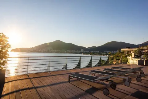 Prostrana terasa sa drvenom podlogom, ležaljkama i pogledom na more i planine. - image 12