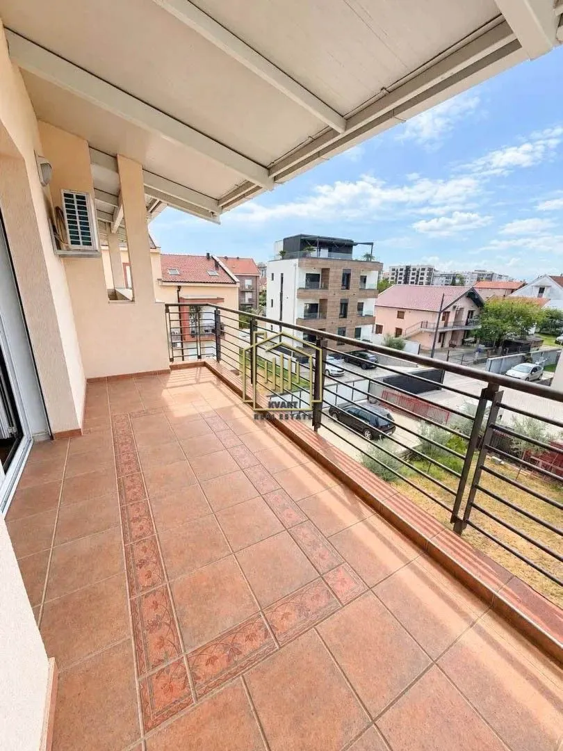Spacious covered terrace with a view of the neighborhood and surrounding buildings.