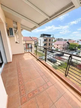 Spacious covered terrace with a view of the neighborhood and surrounding buildings. - image 9
