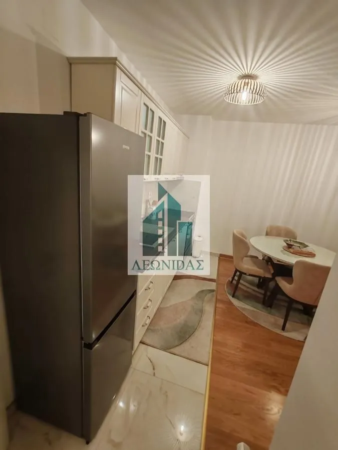 Kitchen with a refrigerator and a dining table with chairs.