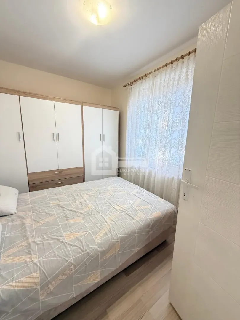 Nameštena spavaća soba sa bračnim krevetom i garderoberom.