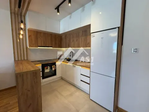 Modern kitchen with white cabinets, wooden accents and built-in appliances. - image 8