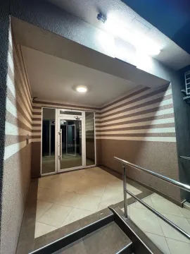 Entrance to a residential building with tiled stairs and glass doors. - image 11