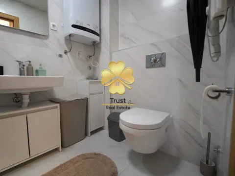 Modernly equipped bathroom with white tiles and toilet. - image 7