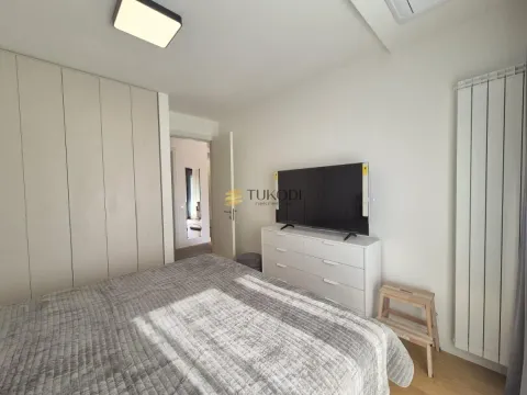 Furnished bedroom with a double bed, wardrobe, and television. - image 7