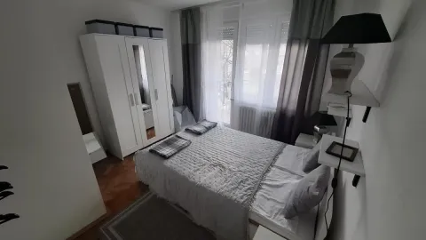 Nameštena spavaća soba sa bračnim krevetom, belim garderoberom i izlazom na terasu. - image 13