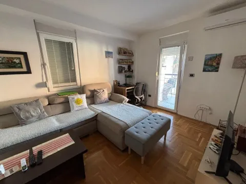 Dnevna soba sa ugaonom garniturom, radnim stolom i izlazom na terasu. - image 8