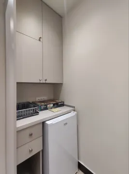 A small kitchenette with built-in cabinets and a mini fridge. - image 4