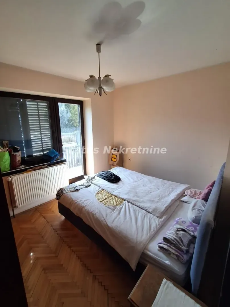 Spavaća soba sa bračnim krevetom i izlazom na terasu.