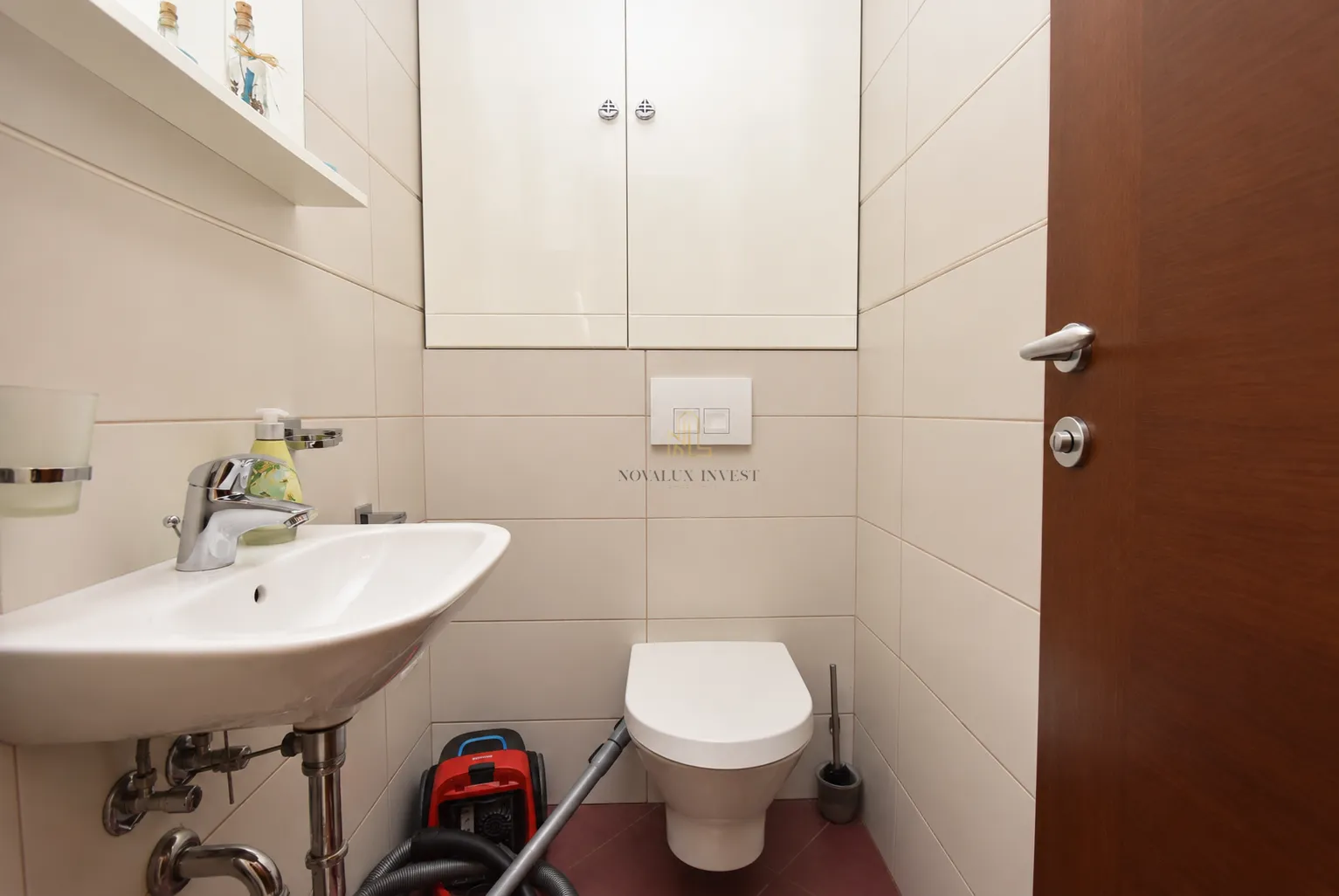 Small bathroom with a washbasin, toilet, and wall cabinet.