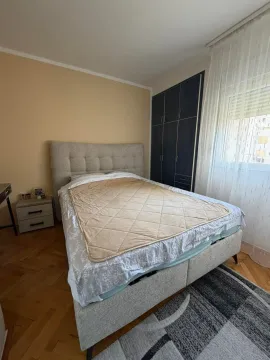 Namještena spavaća soba sa bračnim krevetom, plakarom i prozorom. - image 4