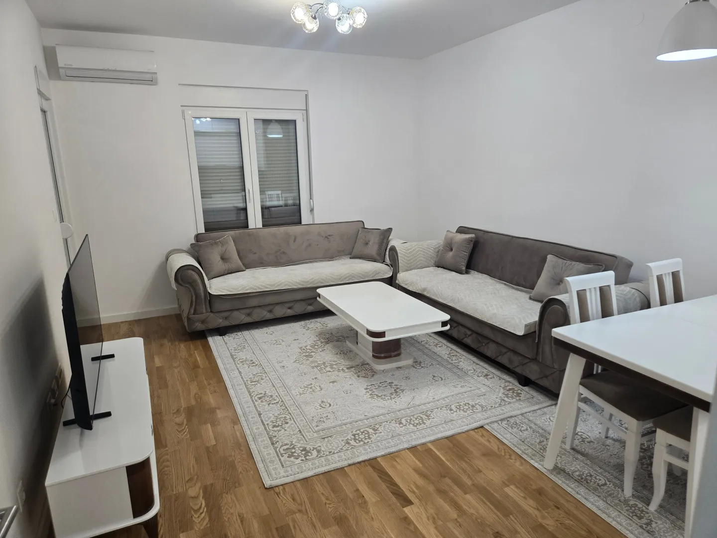 Spacious living room with a sofa set, coffee table, and dining table.