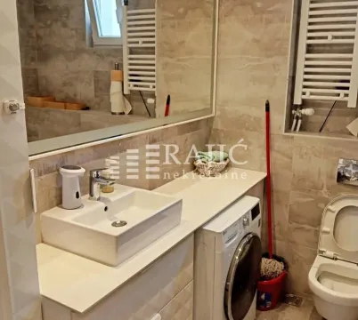 Modernly equipped bathroom with a washbasin and washing machine. - image 11