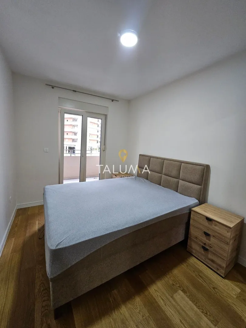 Furnished bedroom with a double bed and a bedside table.