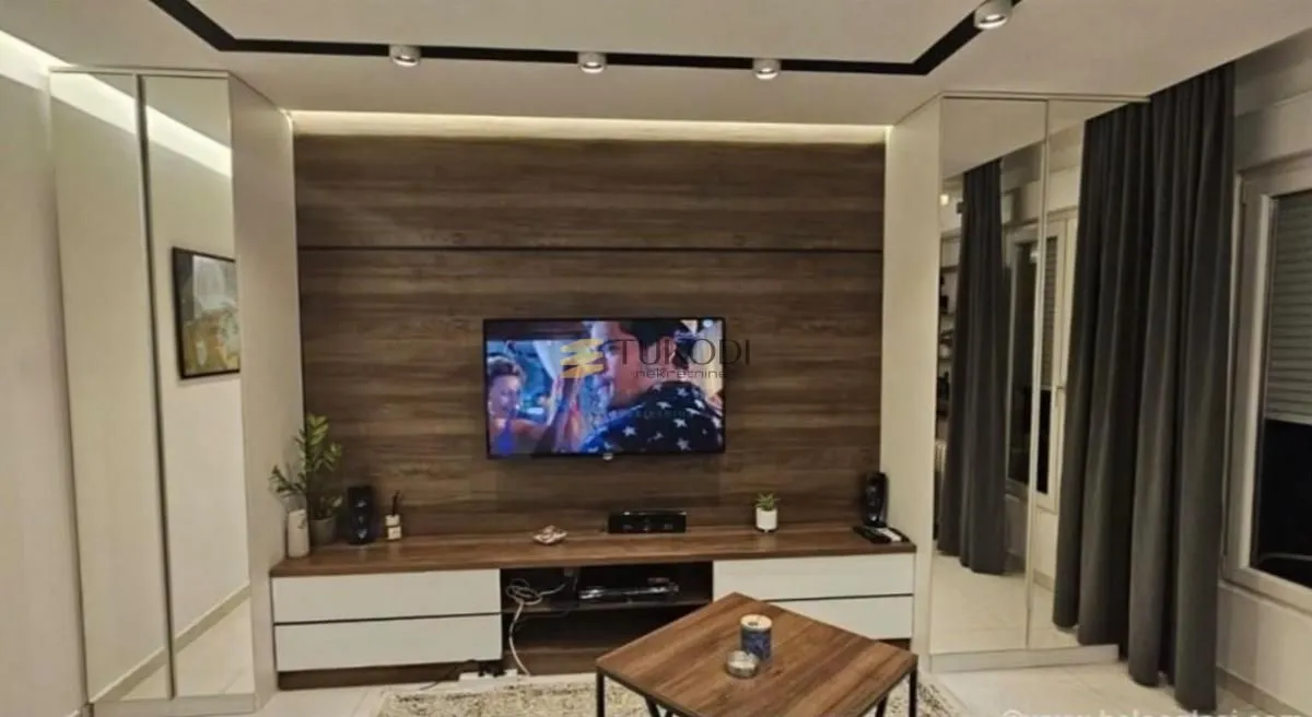 Living room with a wooden wall panel and a television.