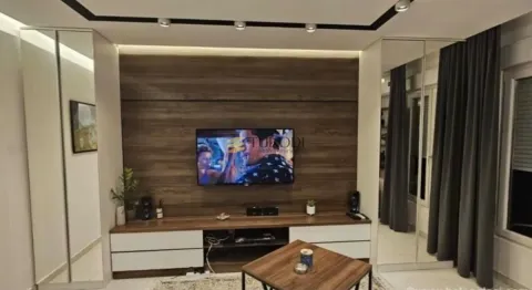 Living room with a wooden wall panel and a television. - image 2