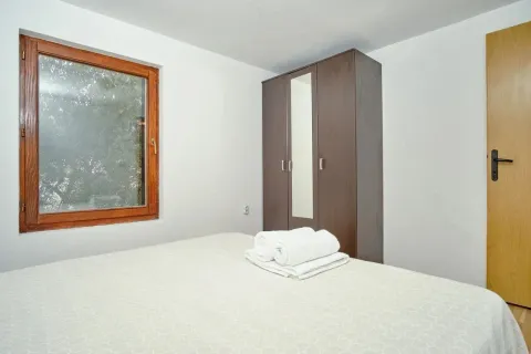 Bright bedroom with a bed, wardrobe, and window. - image 10