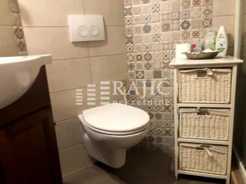 View of a part of the equipped bathroom with a toilet and tiles. - image 9