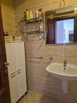Kupatilo sa umivaonikom, ogledalom i bijelim ormarićem. - image 6