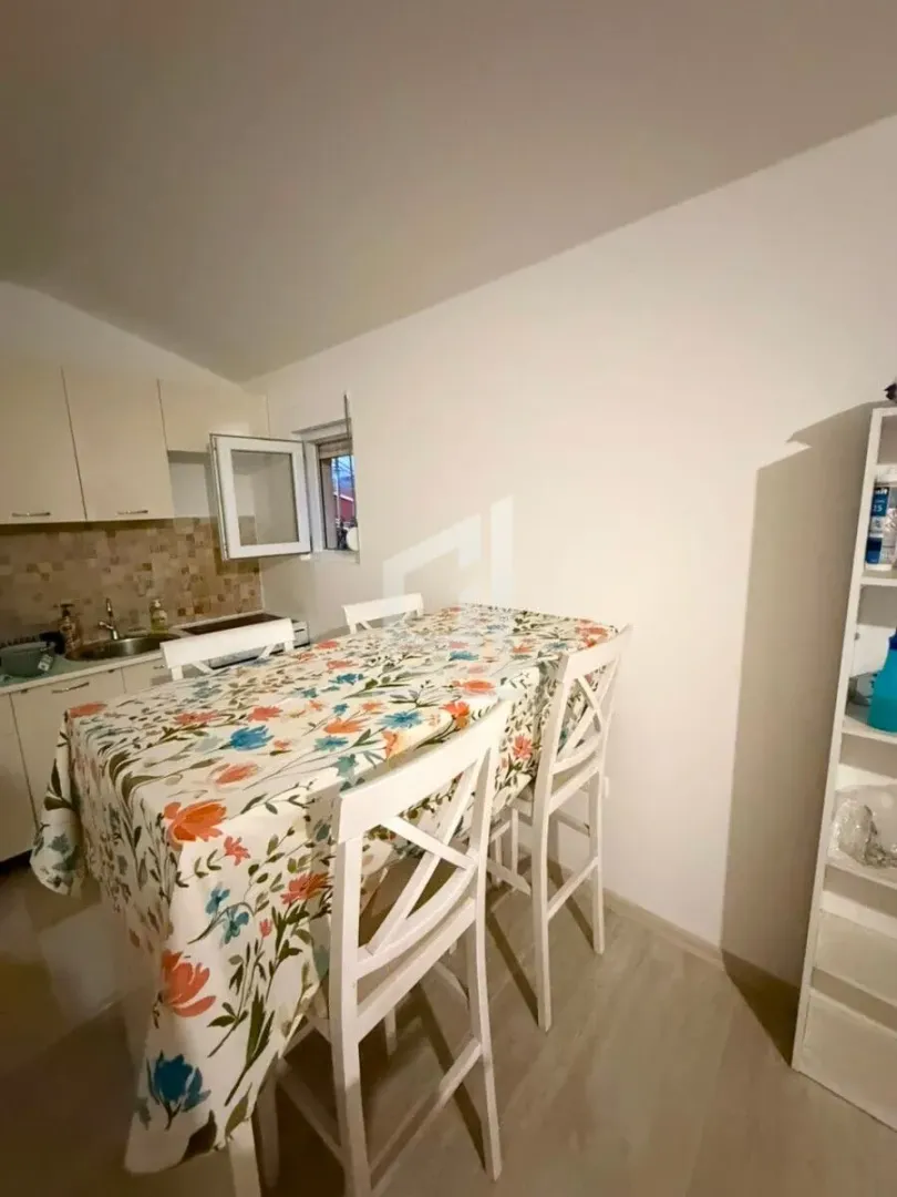 Kitchen with a dining table and white chairs.