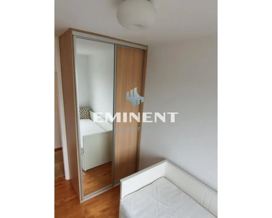 Children's bedroom with a bed and a built-in wardrobe with a mirror.