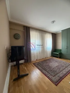 Dnevna soba sa drvenim podom, tepihom i zelenom foteljom. - image 12