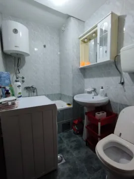 Bathroom with a washing machine and toilet. - image 6