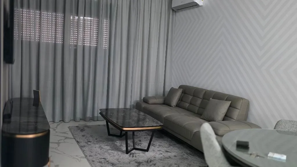Living room with a sofa, coffee table, and dining area.