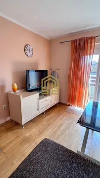 Dnevna soba sa TV komodom, stolom i izlazom na terasu. - image 4