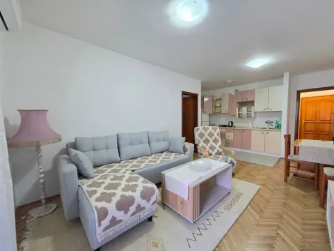 Living room with a sofa, coffee table and a view of the kitchen in the background. - image 5