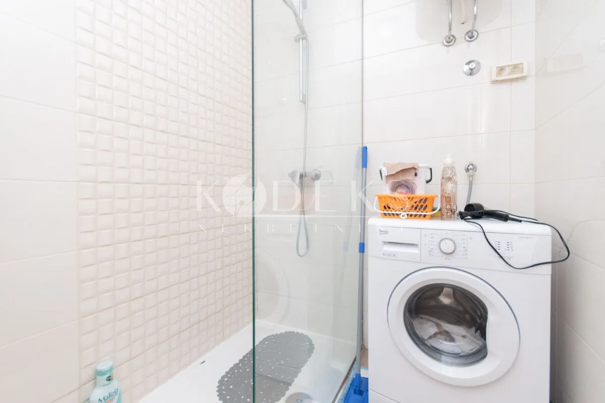 Bathroom with a shower cabin and a washing machine.
