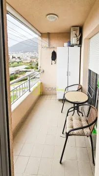 Covered balcony with seating furniture and city view. - image 10
