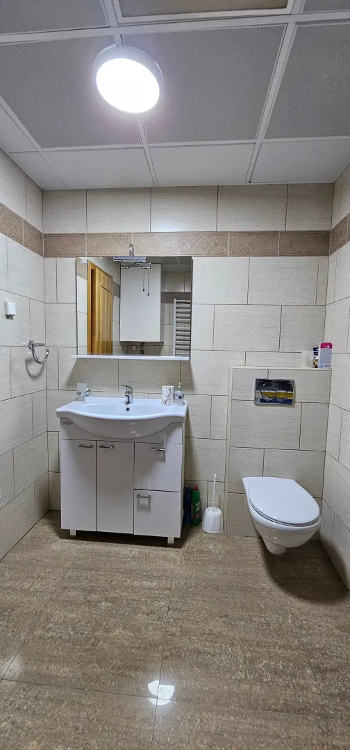Potpuno opremljeno kupatilo sa umivaonikom, ogledalom i toaletom.