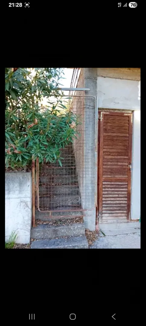 Spoljni dio objekta sa metalnim stepenicama i vratima.