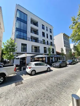 Spoljašnji izgled moderne višestambene zgrade sa poslovnim prostorom u prizemlju i ulicom u prvom planu. - image 7