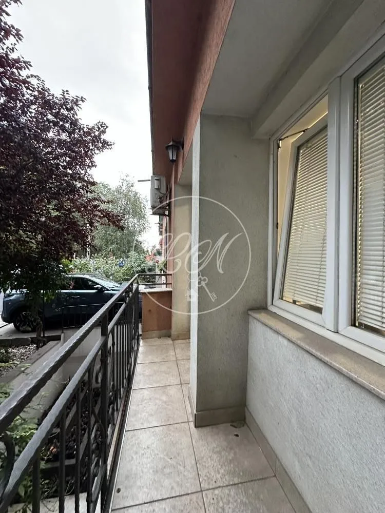 Long tiled balcony with metal railing and green views.